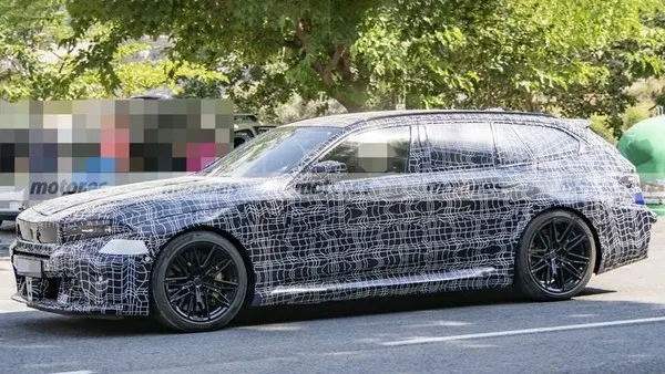 Прототип универсала BMW M5 Touring в камуфляже, вид сбоку: чёрные многоспицевые диски, длинная крыша