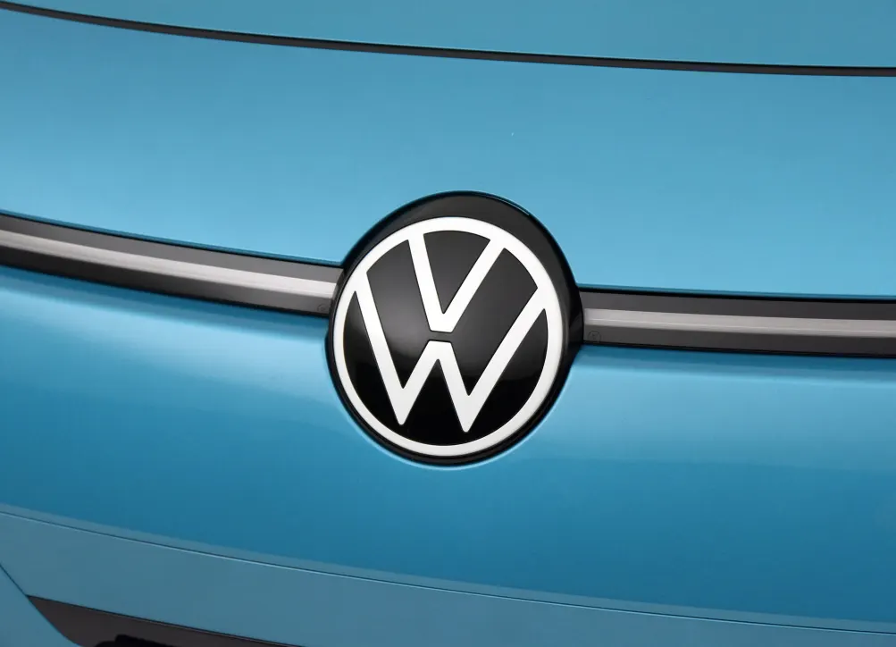 Логотип Volkswagen на передней части голубого автомобиля