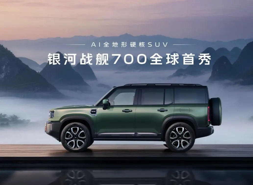Зелёный внедорожник Geely Galaxy Zhanjian 700 сбоку, с запаской на задней двери, на фоне гор в тумане