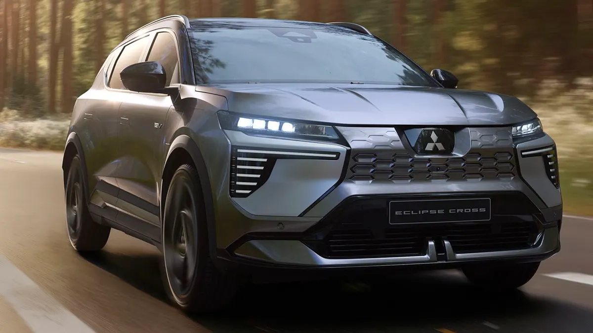 Серый электрический кроссовер Mitsubishi Eclipse Cross в движении по лесной дороге, вид спереди