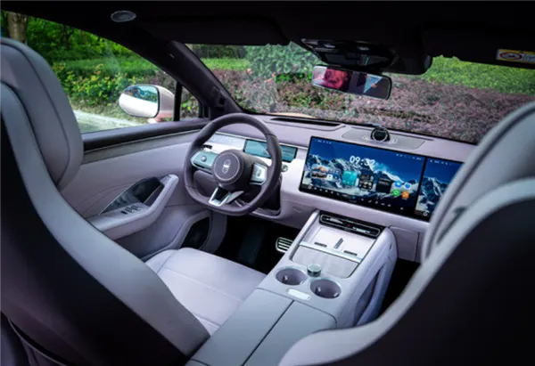 Салон Luxeed R7: светло-серые кресла, руль, широкий центральный экран и консоль с подстаканниками