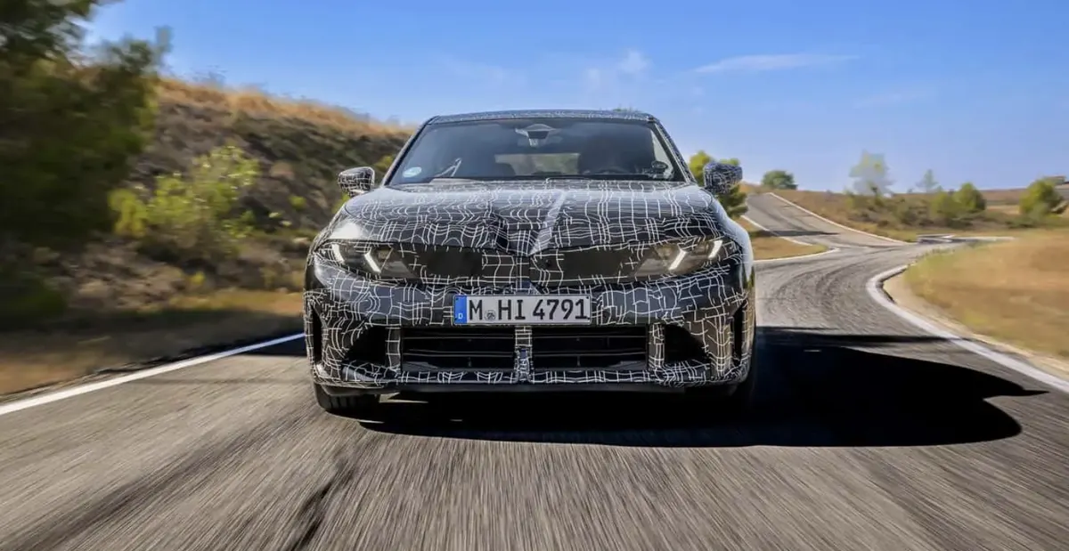 BMW 3 Series (G50) в камуфляже едет по извилистой дороге, вид спереди