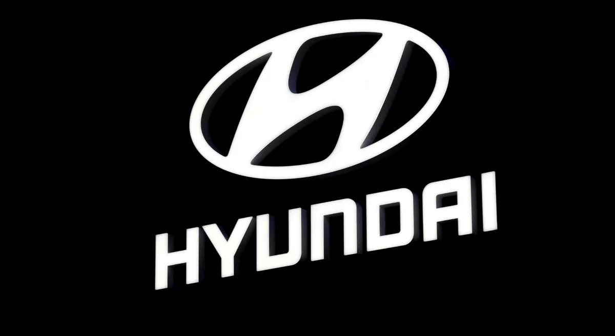 Белый логотип Hyundai на чёрном фоне: стилизованная буква H в овале и надпись HYUNDAI ниже